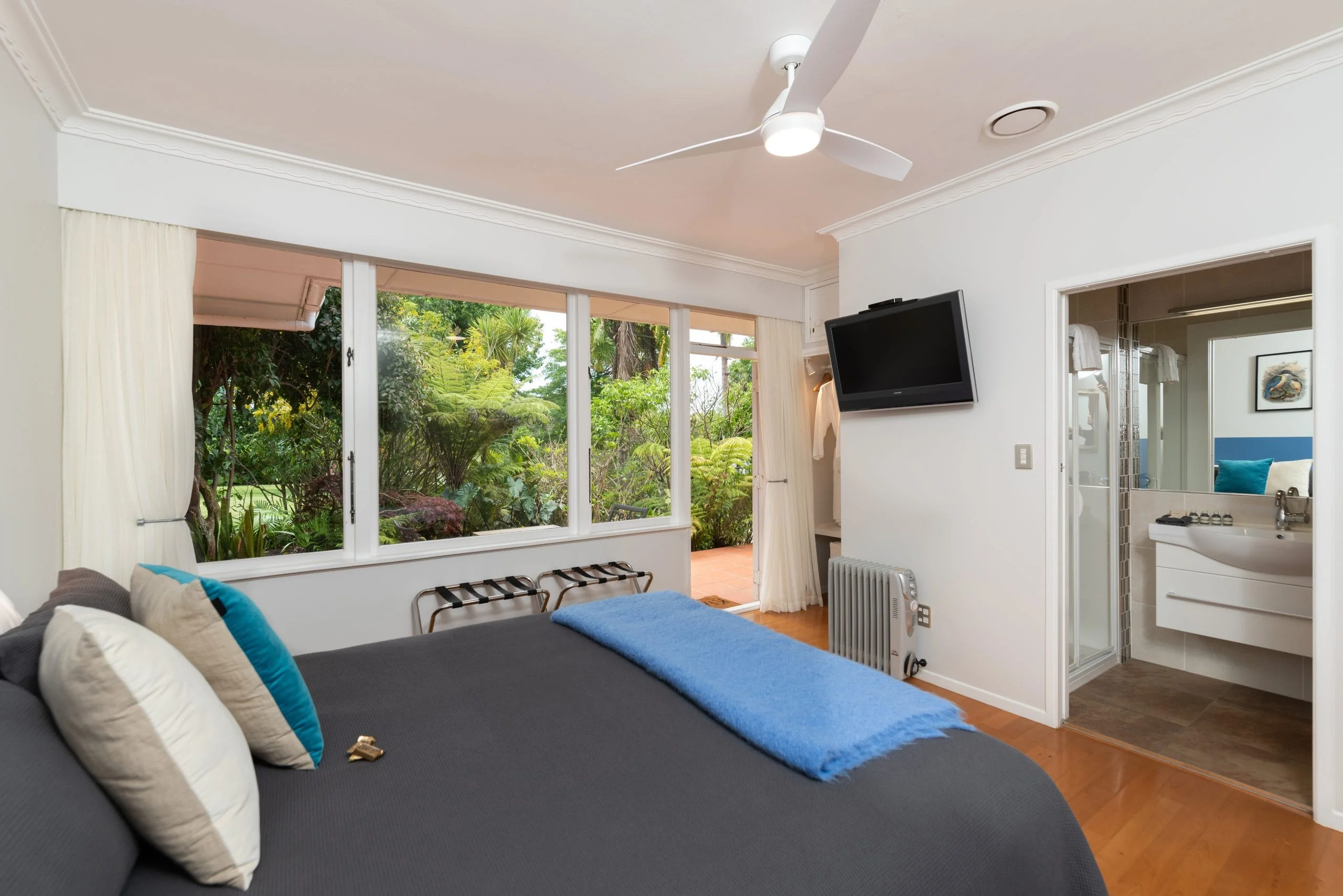 Comfortable king-size bed and smart TV in the Kotarē room at Pāteke Lodge.