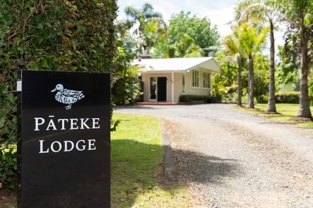 Pateke Lodge entrance way signage and guest parking area.